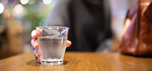 A woman holding water on the table